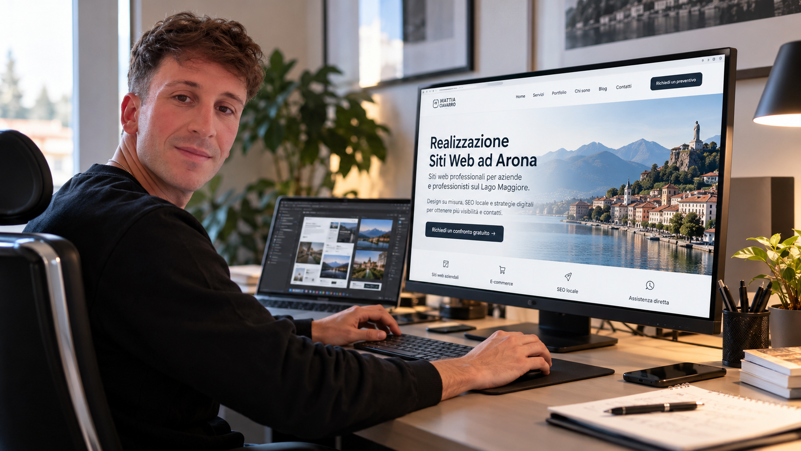 Mattia Ciavarro alla postazione di lavoro, con una proposta grafica di sito web dedicata ad Arona sul monitor